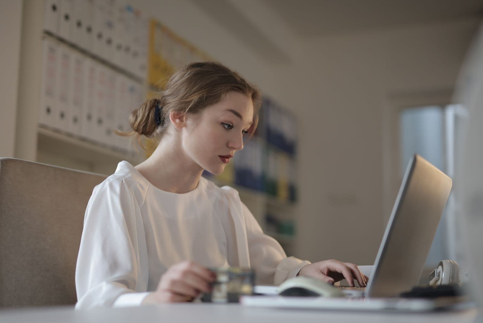 Contabilă tânără lucrând online cu documentele unei firme